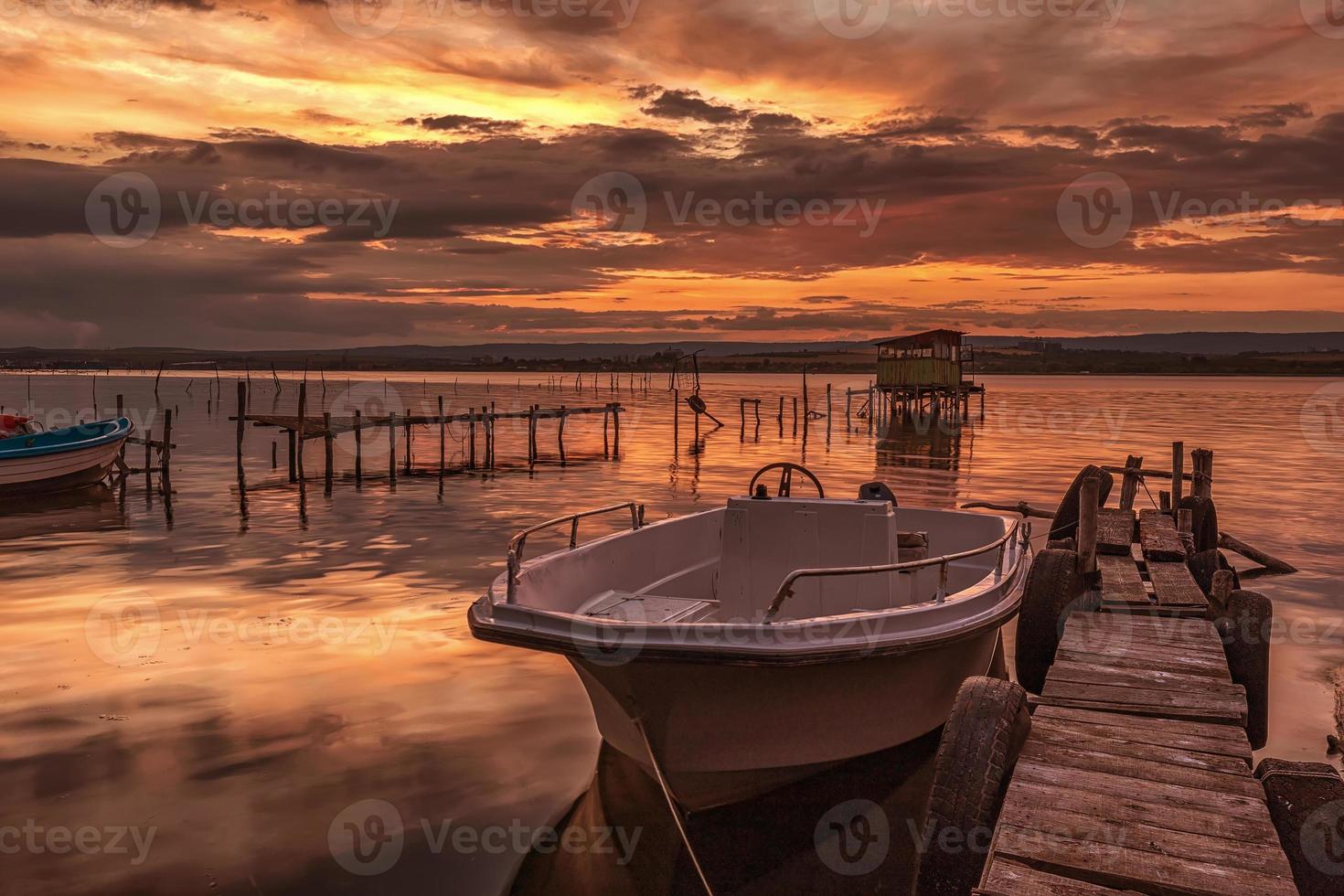 Stimmung und Ruhe an einem Seeufer mit einem Boot an einem Holzsteg foto