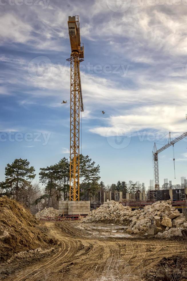 Arbeiten auf der Baustelle mit Kränen und Gebäude. vertikale Ansicht foto