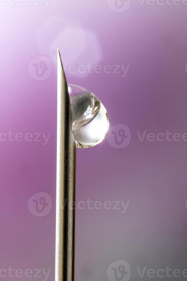 Makrofoto einer medizinischen Nadel zur Injektion mit einem Tropfen Flüssigkeit. foto