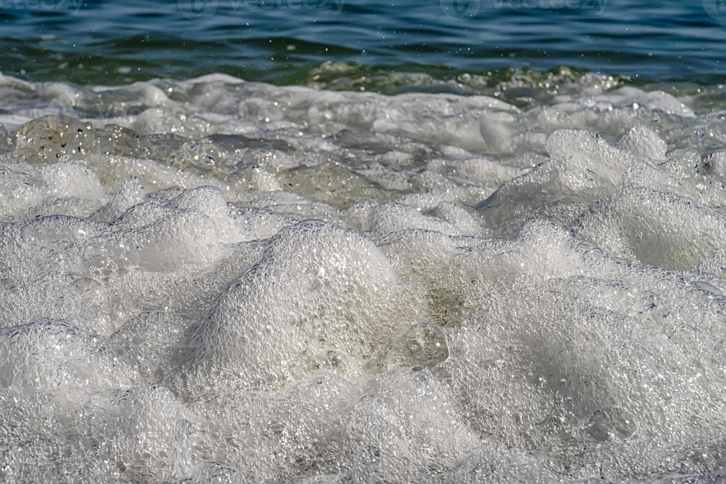 Vorderansicht des Meereswellenspritzers mit Schaum. Nahansicht foto