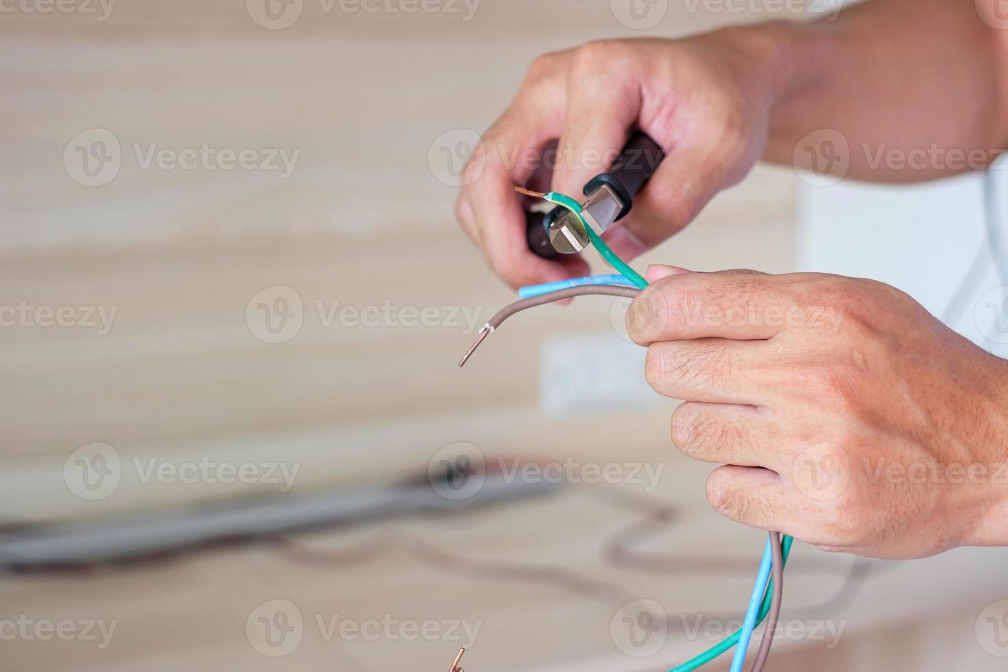 elektriker schneidet elektrische drähte mit einer zange, verdrahtungskabelinstallation für steckdosenstecker. Reparatur, Renovierung, Reparatur, Service und Entwicklung von Haus- und Wohnungskonzepten foto