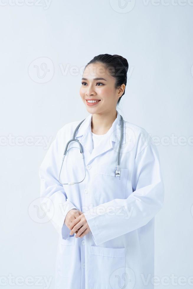 Ärztin in weißer Uniform, die mit verschränkten Armen steht. isoliertes weibliches Porträt. foto