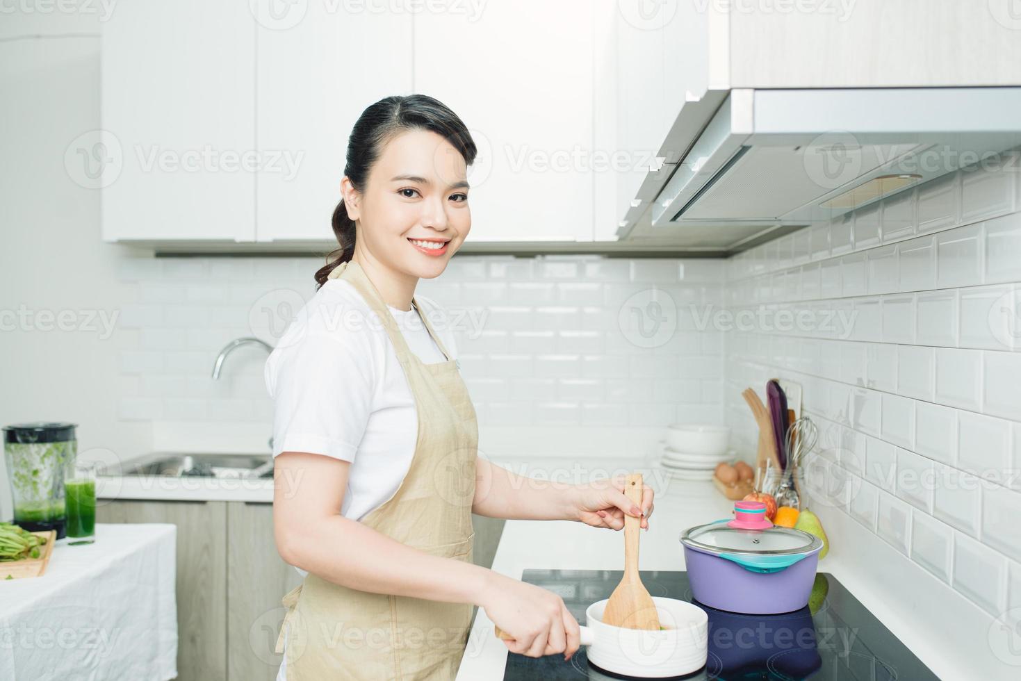 schöne Frau, die etwas in der Küche kocht foto