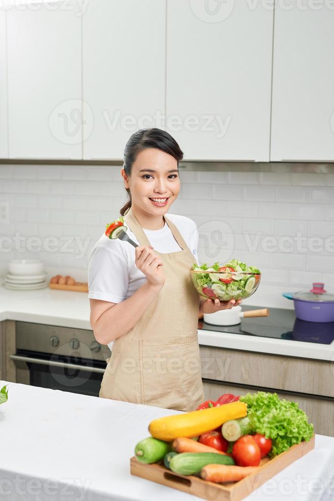 vegane Lebensweise. gesunde Ernährung. Weibchen mit Salatschüssel mit frischem Gemüse. glückliche junge Hausfrau. foto