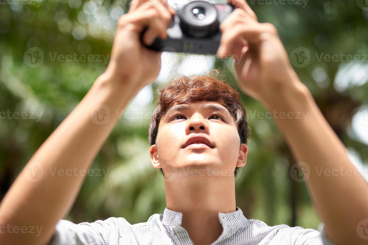 Fotograf, der im Freien fotografiert, verwendet er eine Digitalkamera foto