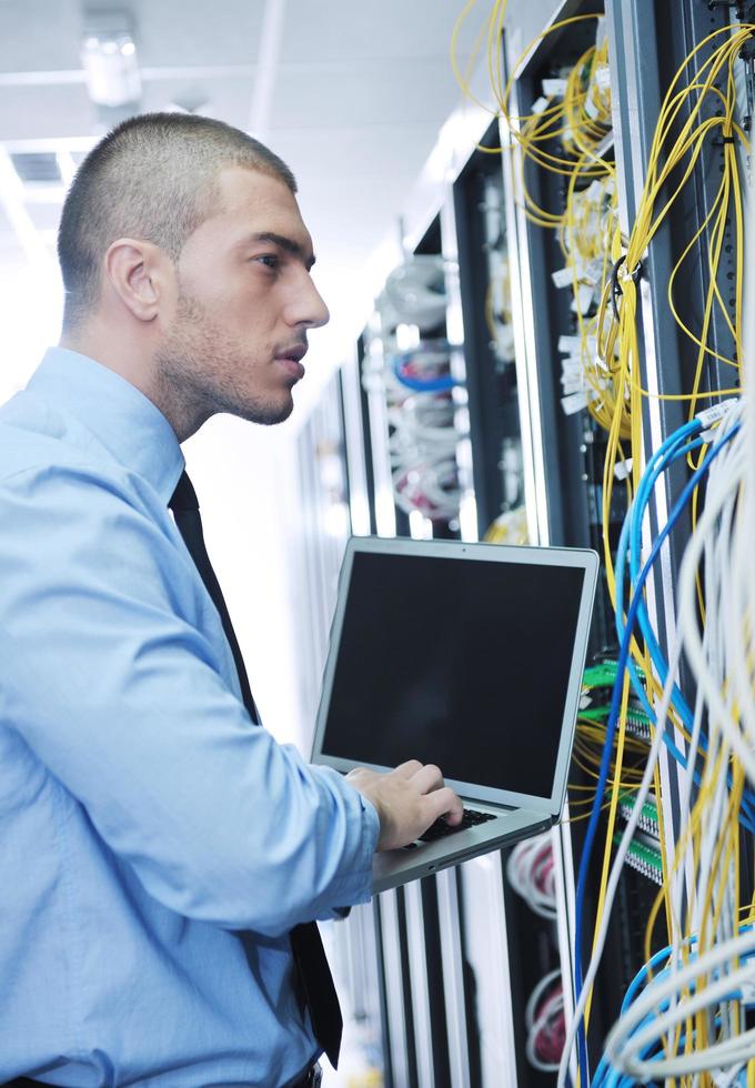 Geschäftsmann mit Laptop im Netzwerkserverraum foto