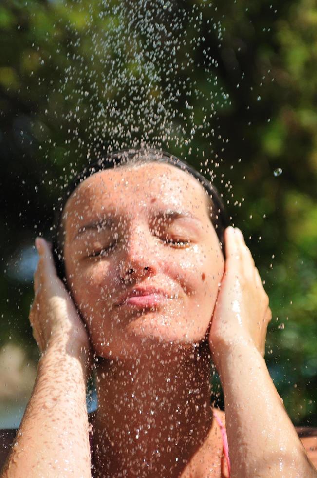 junge hübsche frau, die sich unter der dusche entspannt foto