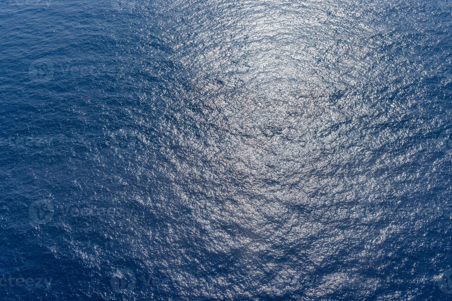 Luftaufnahme der Meeresoberfläche, sonniger, tiefblauer Ozeanhintergrund. kräuselt Wellen foto