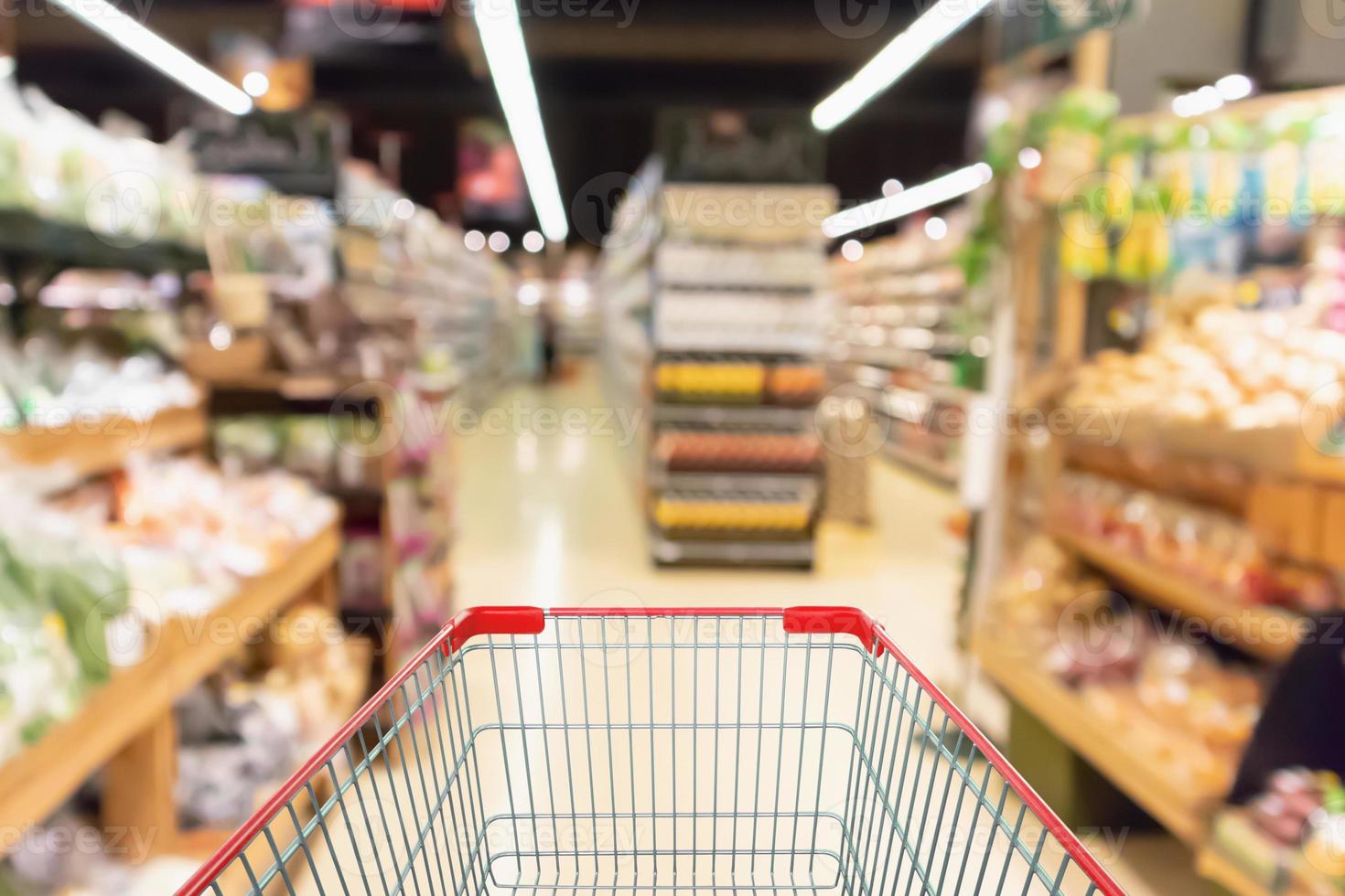 Leerer Einkaufswagen mit abstraktem Supermarkt Lebensmittelgeschäft unscharfer defokussierter Hintergrund mit Bokeh-Licht foto