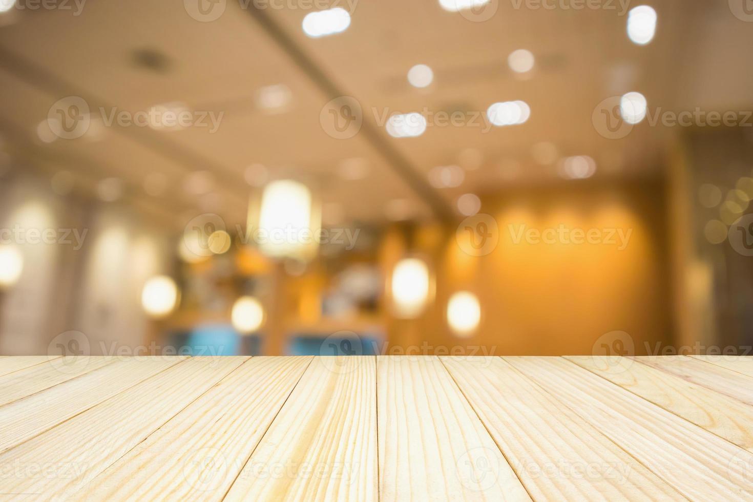 Holztisch mit abstraktem verschwommenem Café-Restaurant mit defokussiertem Hintergrund von Bokeh-Lichtern foto