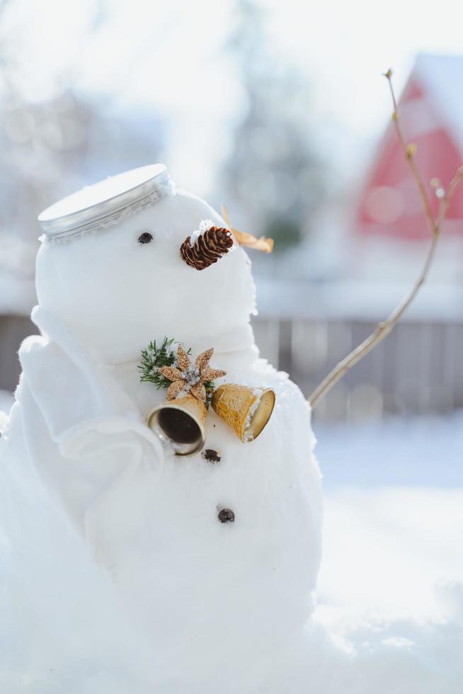 Grußkarte der frohen Weihnachten und des guten Rutsch ins Neue Jahr mit Kopienraum. Viele Schneemänner, die in der Winterweihnachtslandschaft stehen. Winterhintergrund. Schneemann mit trockener Blume und Kiefer. Frohe Feiertage und Feiern. foto