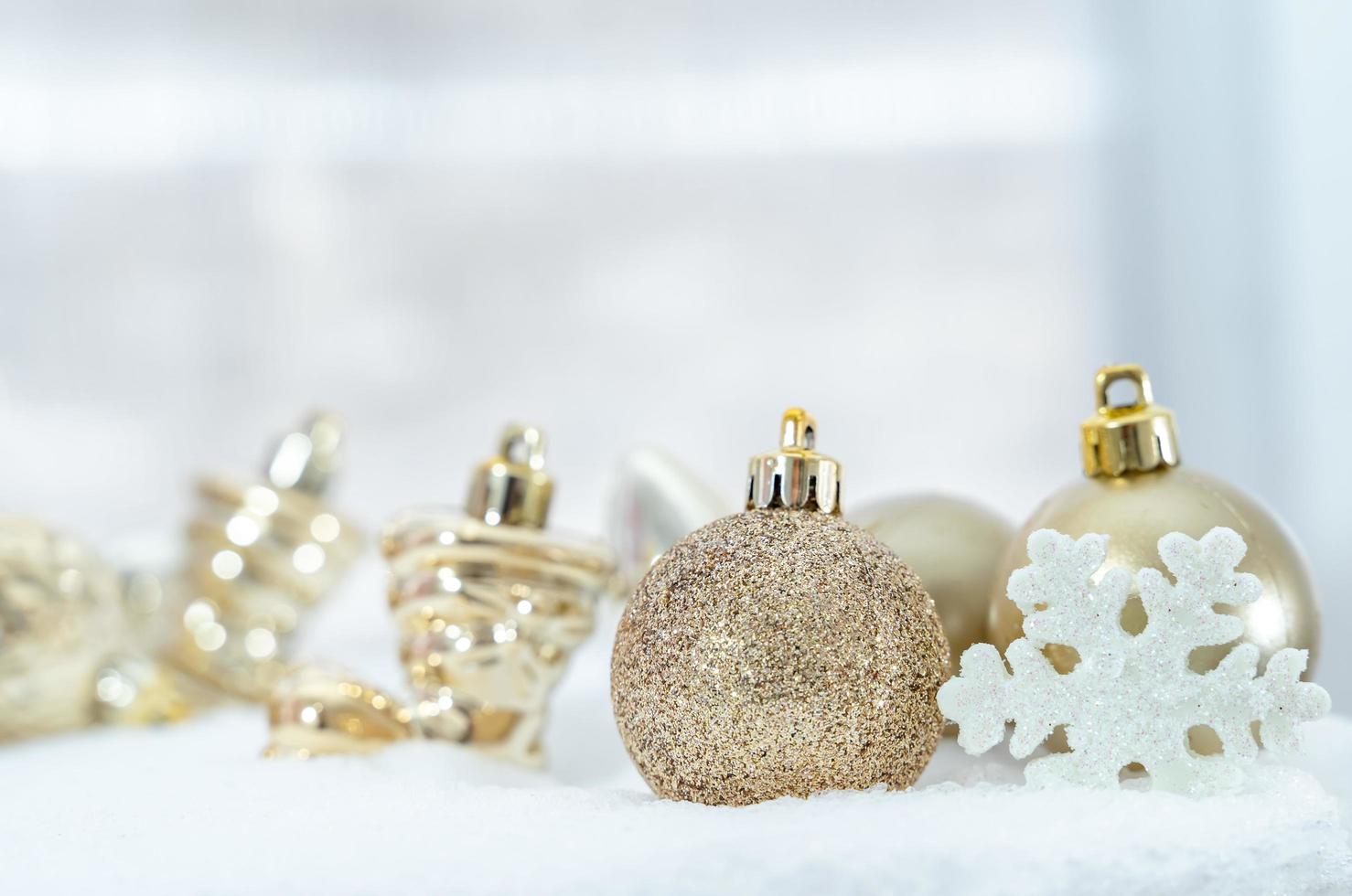 weihnachten des winters - weihnachtskugeln mit band auf schnee, winterferienkonzept. weihnachtsrote kugeln, goldene kugeln, kiefern- und schneeflockendekorationen im schneehintergrund foto