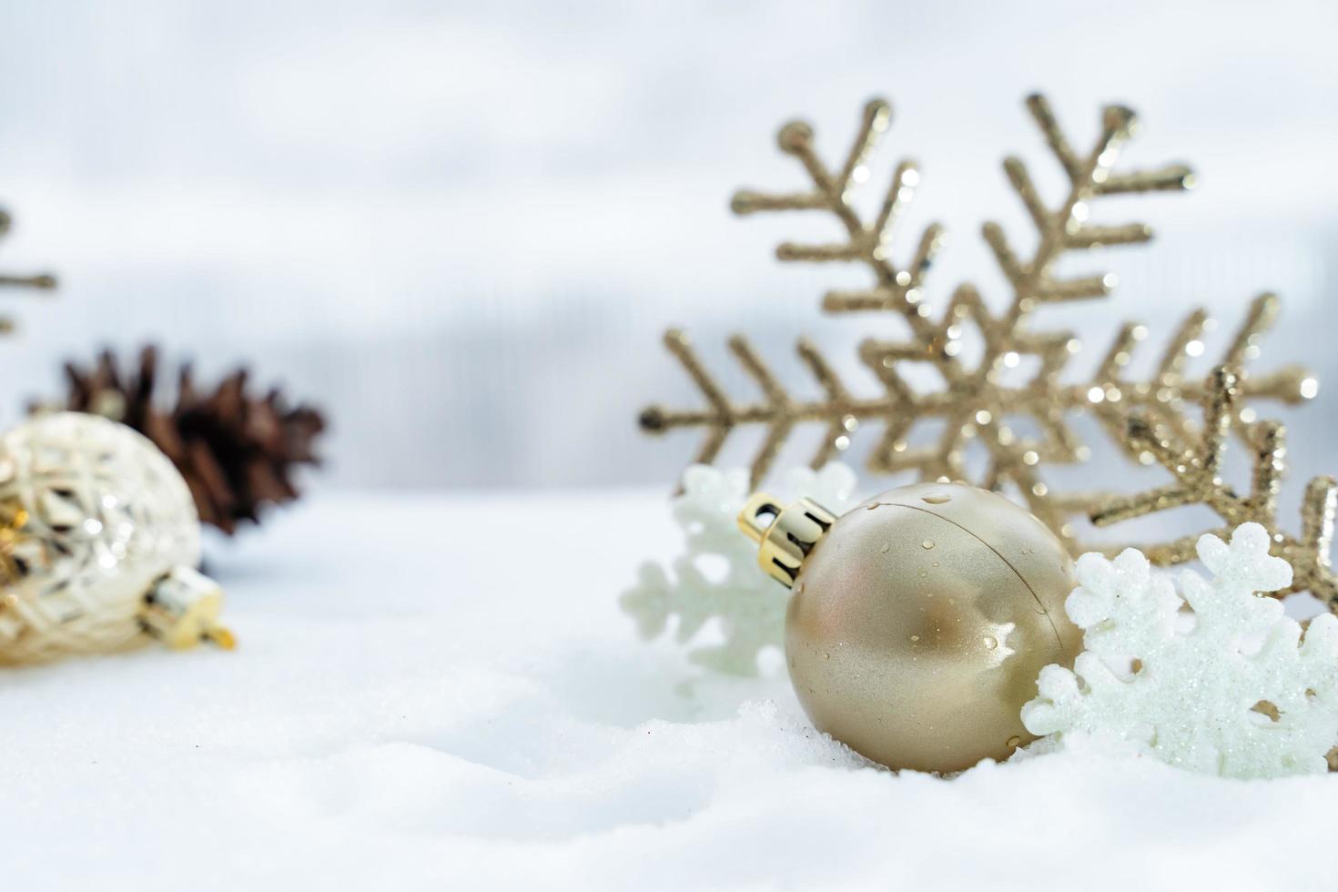 weihnachten des winters - weihnachtskugeln mit band auf schnee, winterferienkonzept. weihnachtsrote kugeln, goldene kugeln, kiefern- und schneeflockendekorationen im schneehintergrund foto