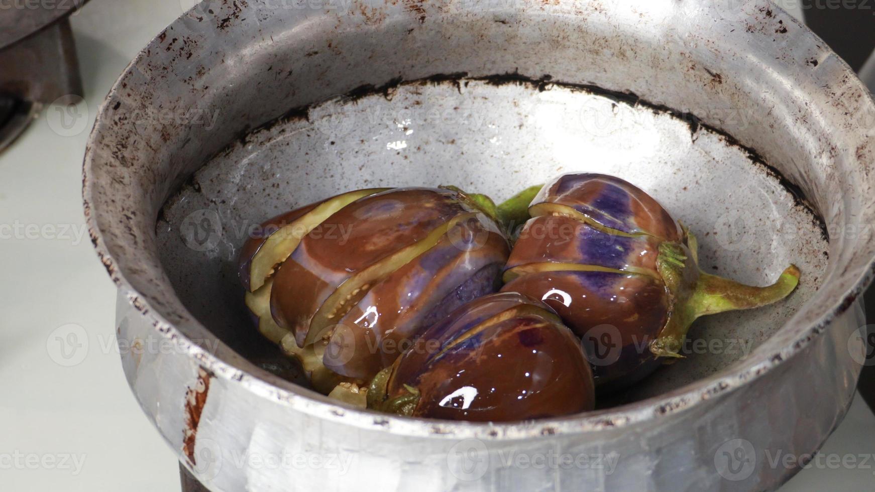 ganze frische Auberginen oder Auberginen-Bringal, lila Auberginen-Auberginen, gedämpft, gekocht mit Gewürzen und Kräutern zum Einfrieren und Konservieren für späteres Kochen foto