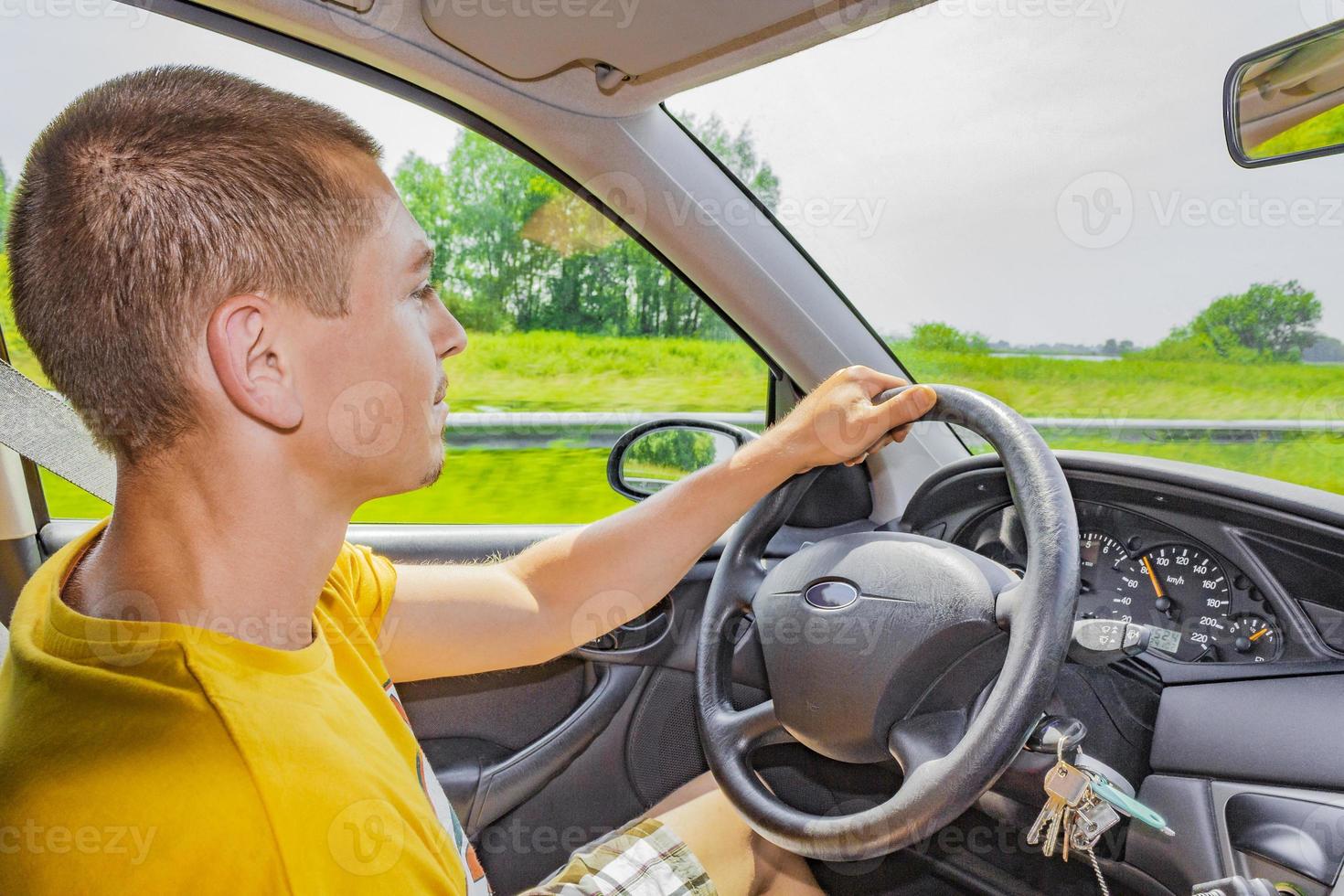 junger cooler mann junge lenkt und fährt auto in die niederlande. foto