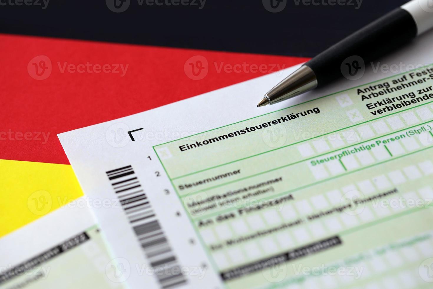 deutsches einkommensteuererklärungsformular mit stift auf flagge aus nächster nähe. das konzept der steuerberichterstattung in deutschland foto