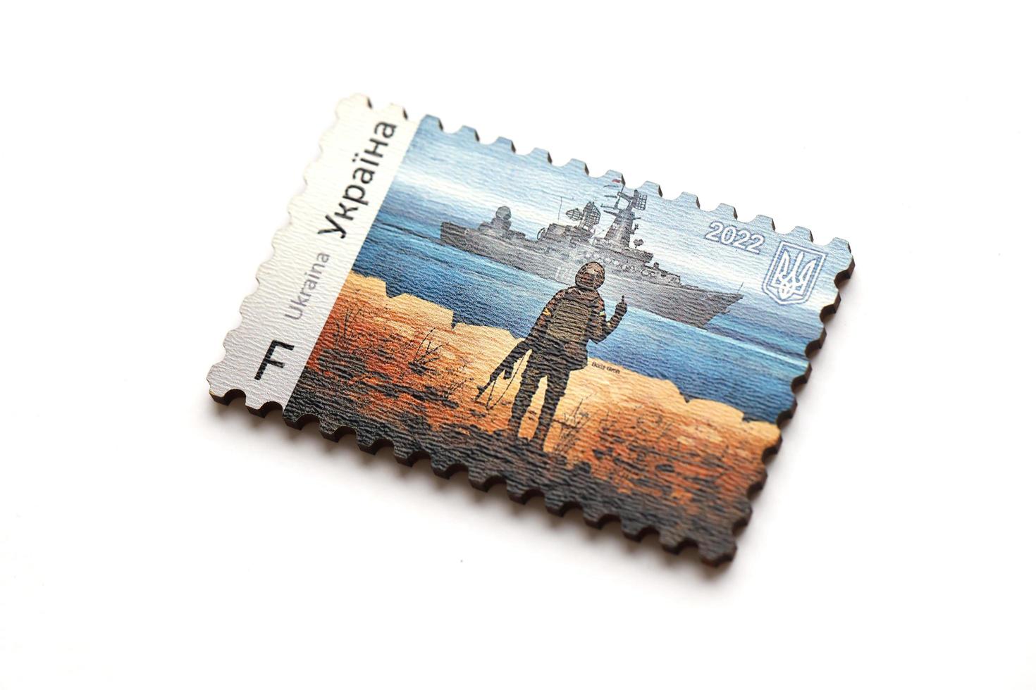 ternopil, ukraine - 2. september 2022 berühmter ukrainischer poststempel mit russischem kriegsschiff und ukrainischem soldaten als hölzernes souvenir auf weißem hintergrund foto