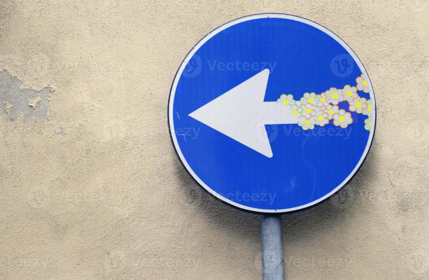 ein richtungsweisendes Straßenschild mit darauf angebrachten Blumenaufklebern. foto