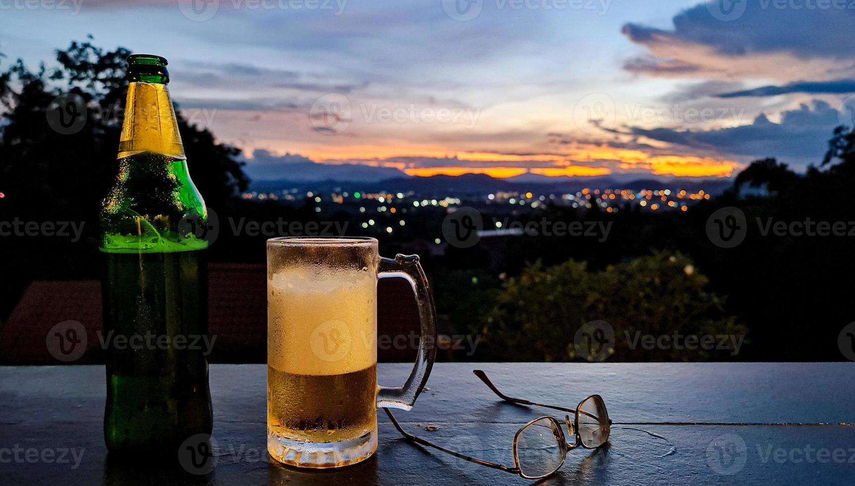 Bier mit der Städtelandschaft bei Sonnenuntergang foto