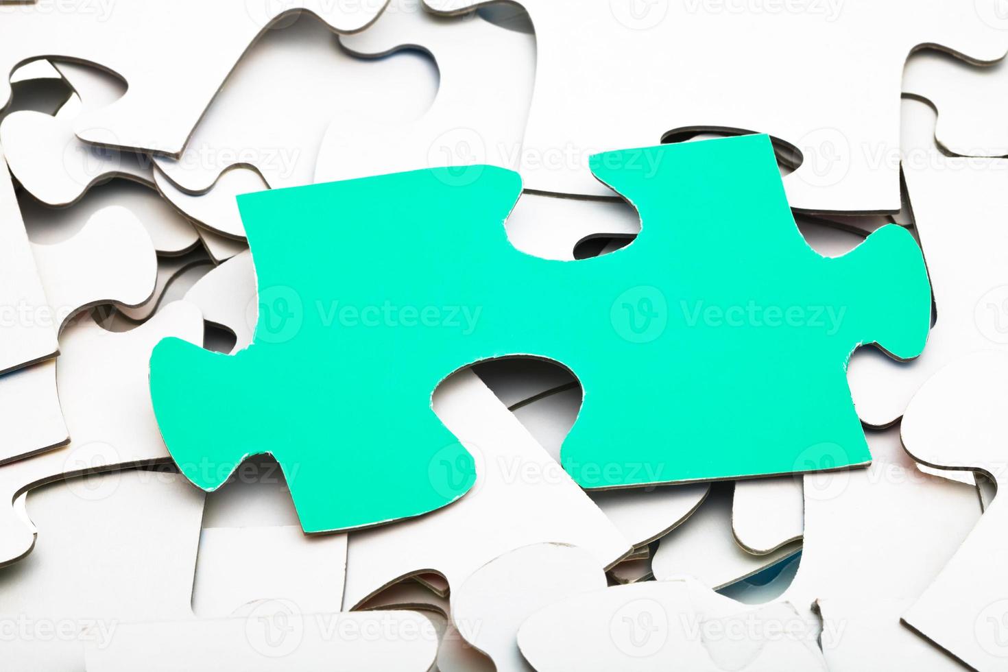 ein grünes Stück auf einem Haufen weißer Puzzles foto