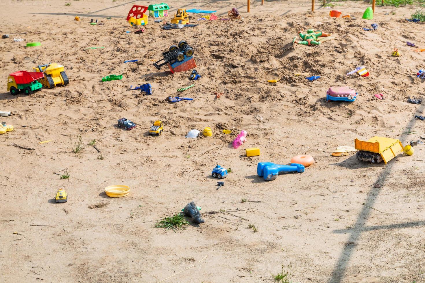 verlassene Spielzeuge auf dem Sandspielplatz im Freien foto
