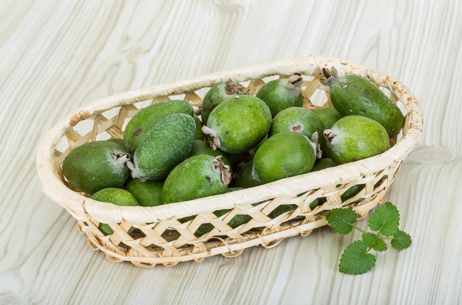 Feijoa in einem Korb auf Holzhintergrund foto