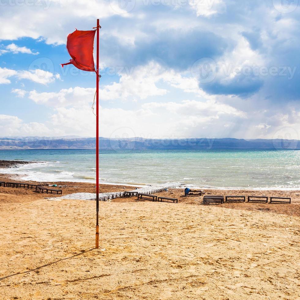 Rote Fahne am Strand am Toten Meer in der Wintersaison foto