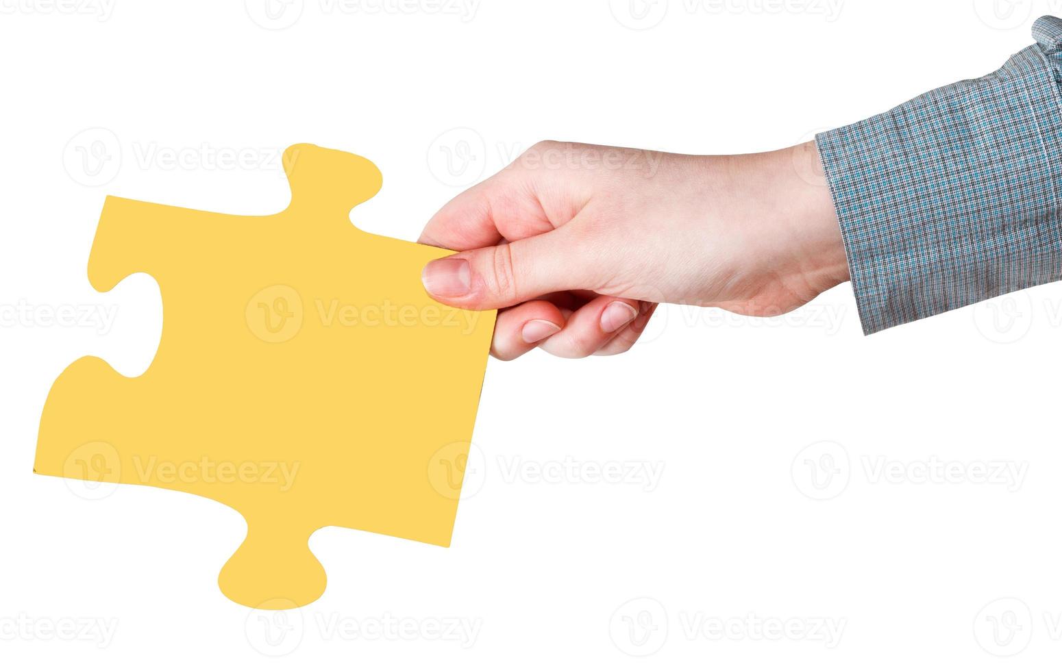 weibliche Hand mit gelbem Puzzleteil foto