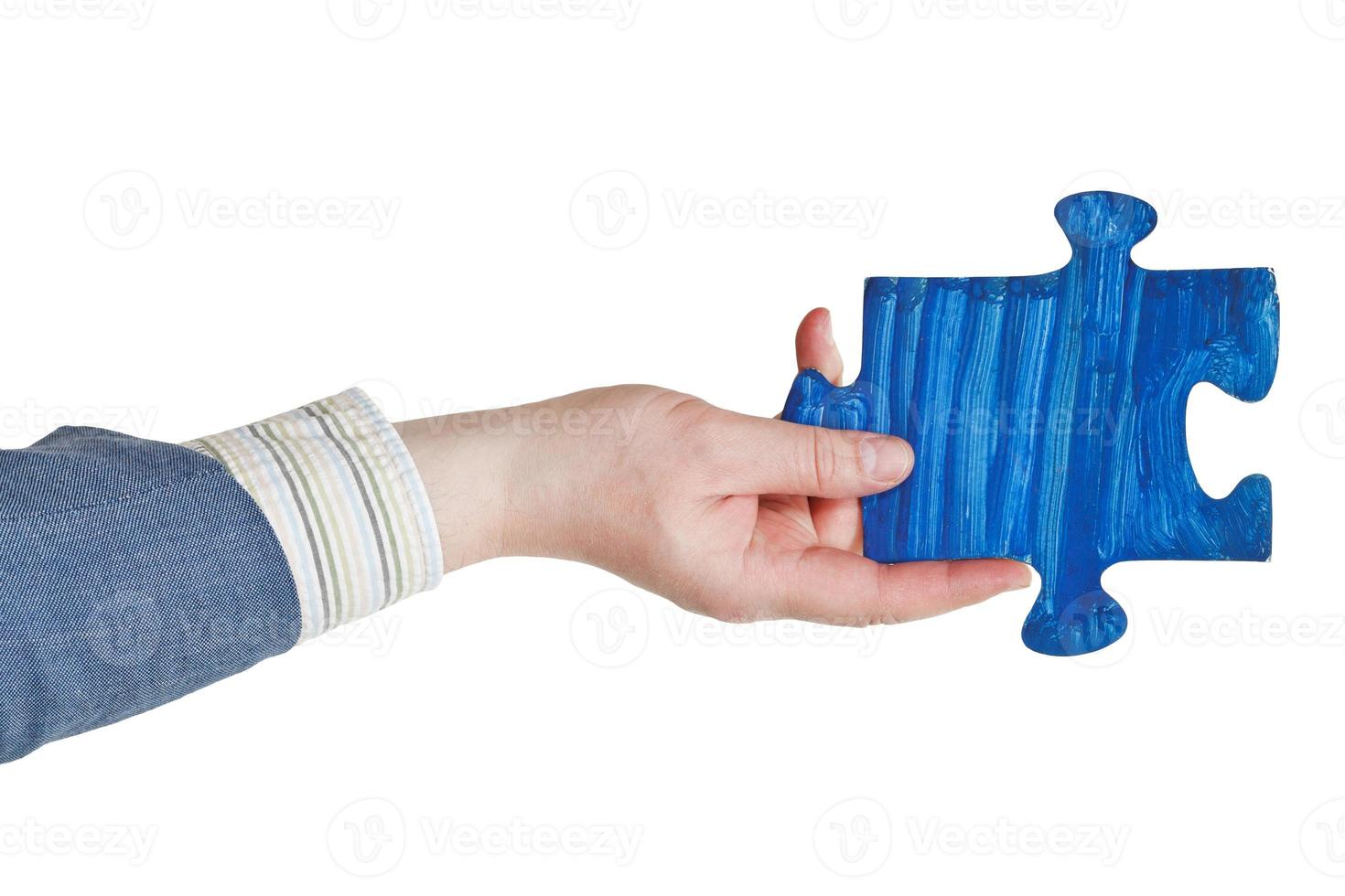 männliche Hand mit gemaltem blauem Puzzleteil foto