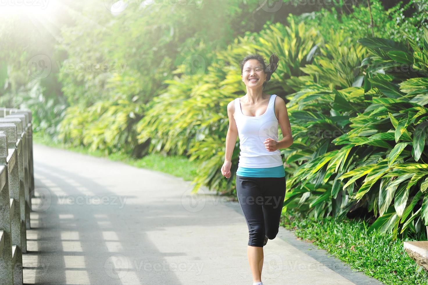 junge asiatische Frau, die im Park joggt foto