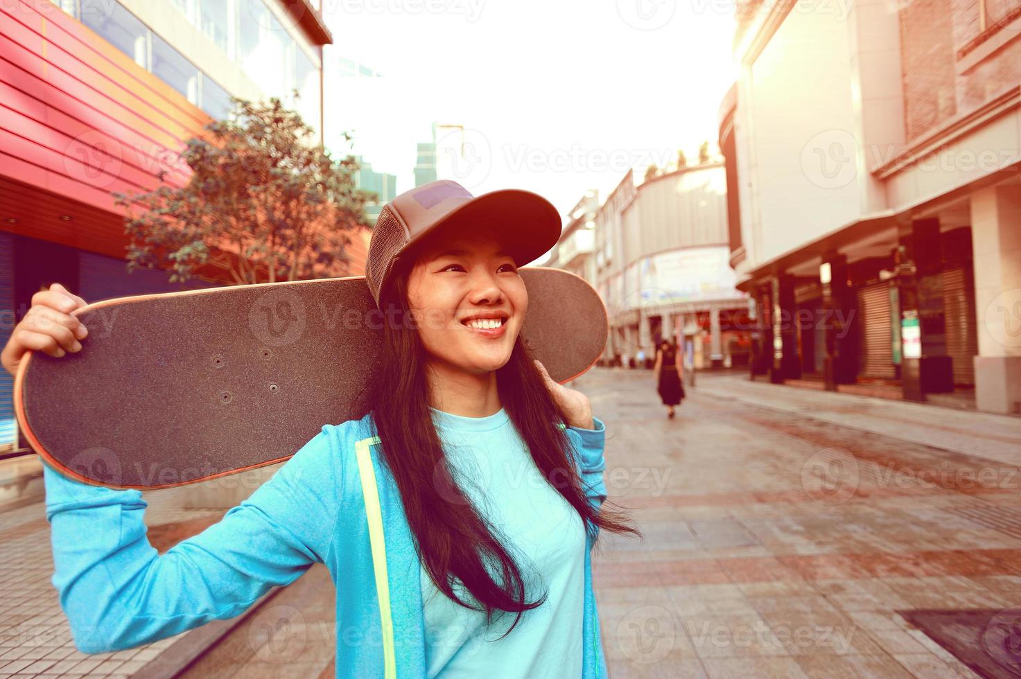 junge Frau Skateboarder auf der Straße foto
