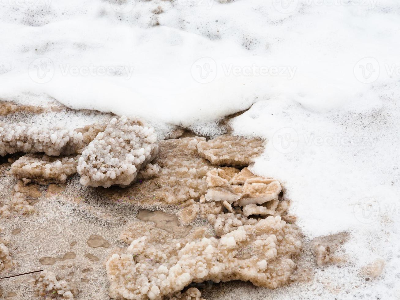 stücke von natürlichem salz im schaum des toten meeres foto