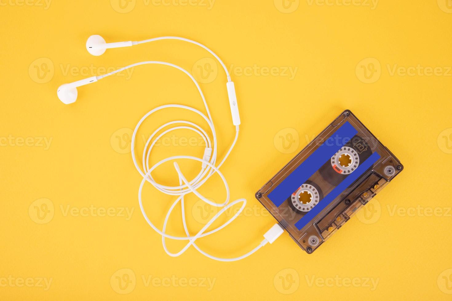 Tonbandkassette und weiße Kopfhörer. Komposition in Form eines Spielers auf gelbem Hintergrund. foto