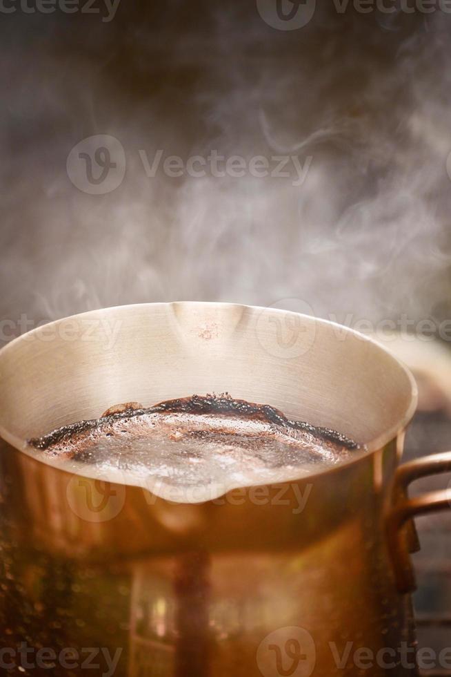 natürlicher, frisch gerösteter Kaffee wird in einem Metalltürk über dem Feuer zubereitet. heißer kaffee mit schaum. foto