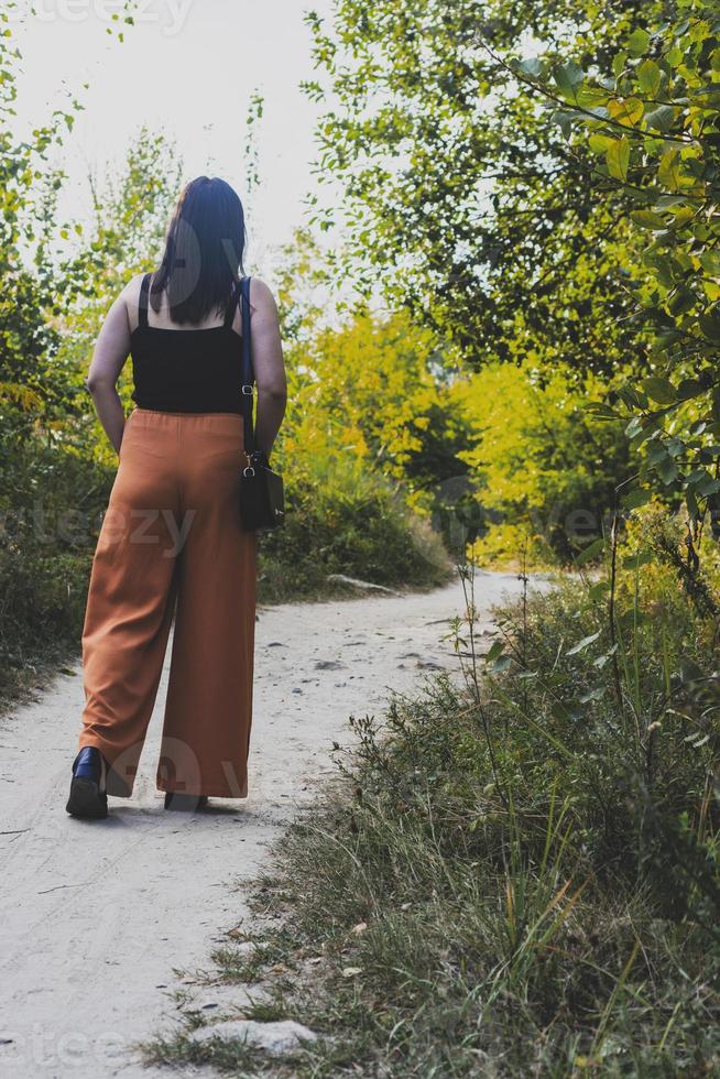 Frau, die im herbstlichen Wald Naturpfad spazieren gehen auf Trail Wald Hintergrund. foto