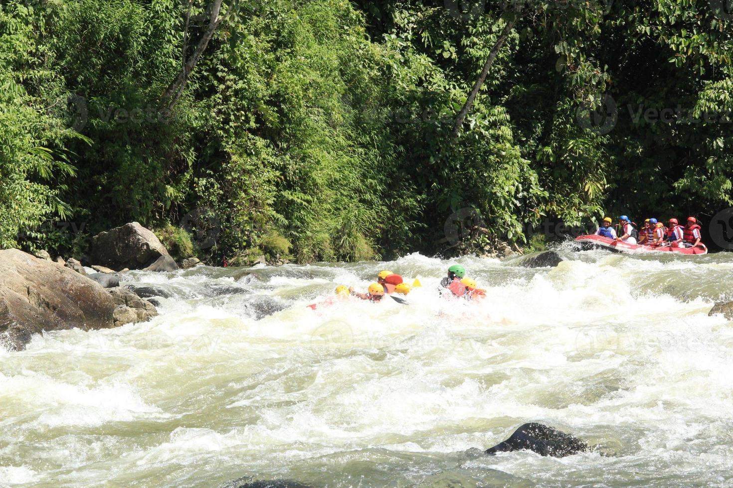 Foto von Rafting-Aktivitäten einer Gruppe von Menschen auf einem felsigen Fluss mit starker Strömung