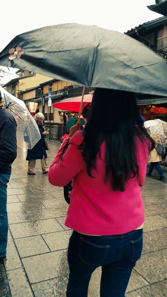 kyoto, japan am 8. april 2019. menschen gehen mit regenschirmen spazieren, weil es regnet. foto