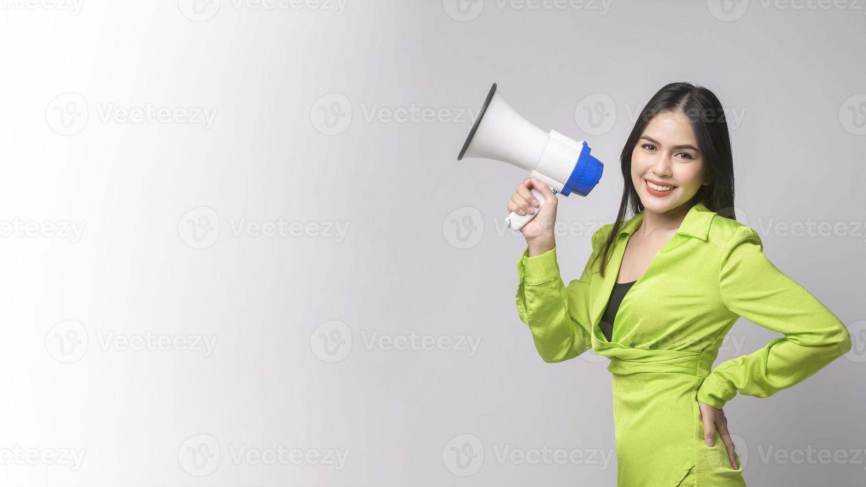 junge schöne Frau, die Megaphon über weißem Hintergrundstudio hält. foto