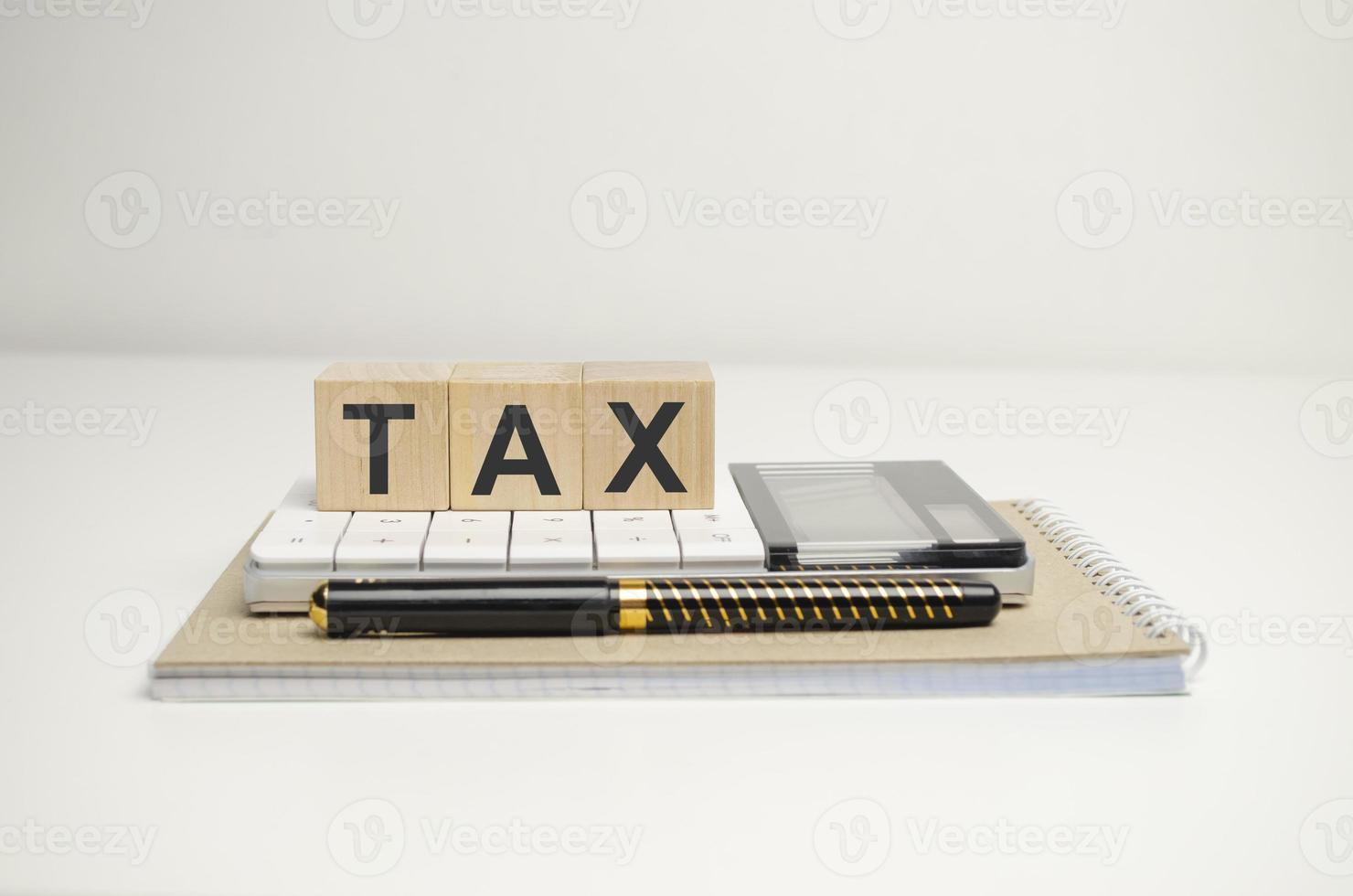 Nahaufnahme der Rechnung mit Taschenrechner und Steuertext auf Holzblöcken foto