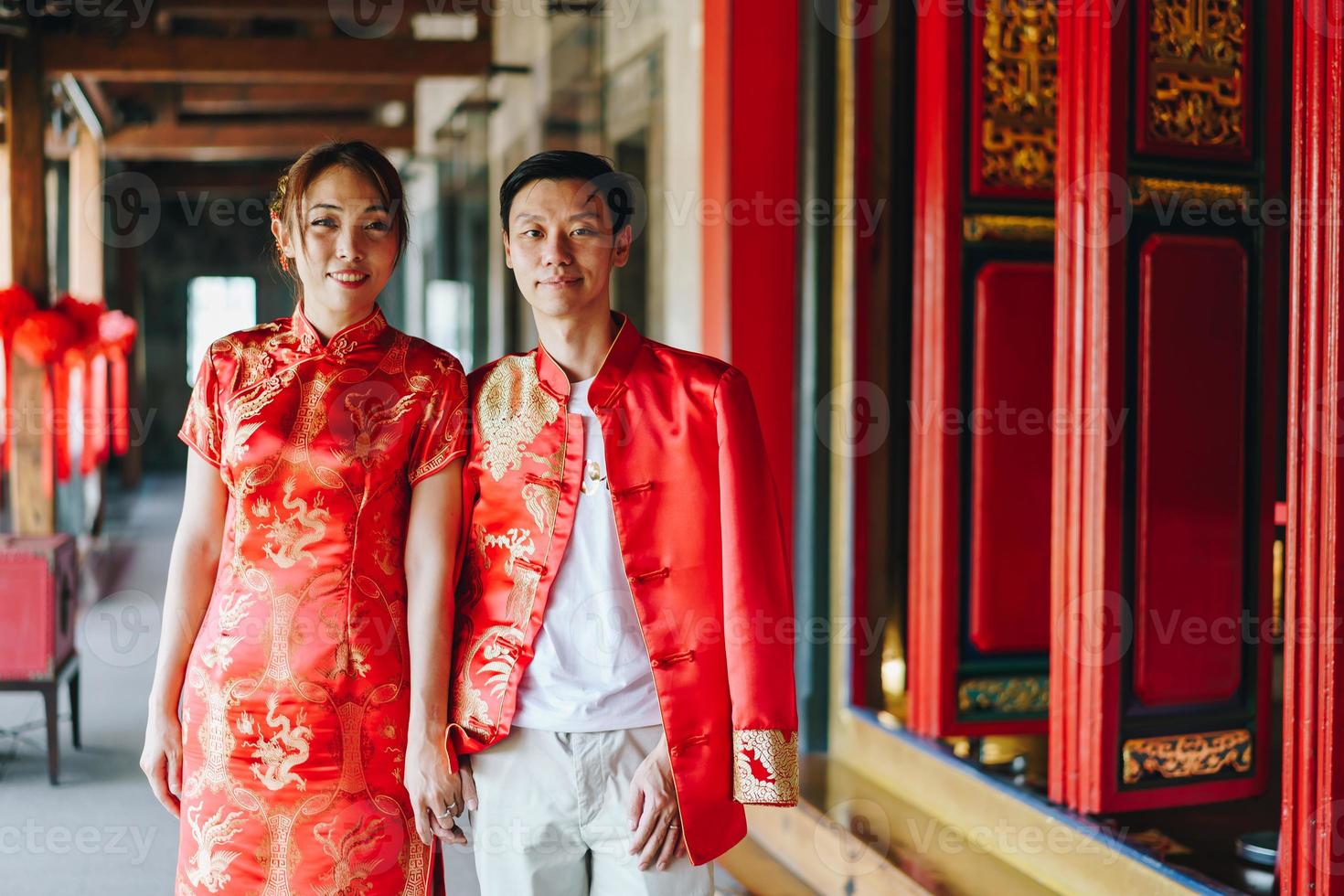 glückliches junges asiatisches paar in chinesischen traditionellen kleidern foto