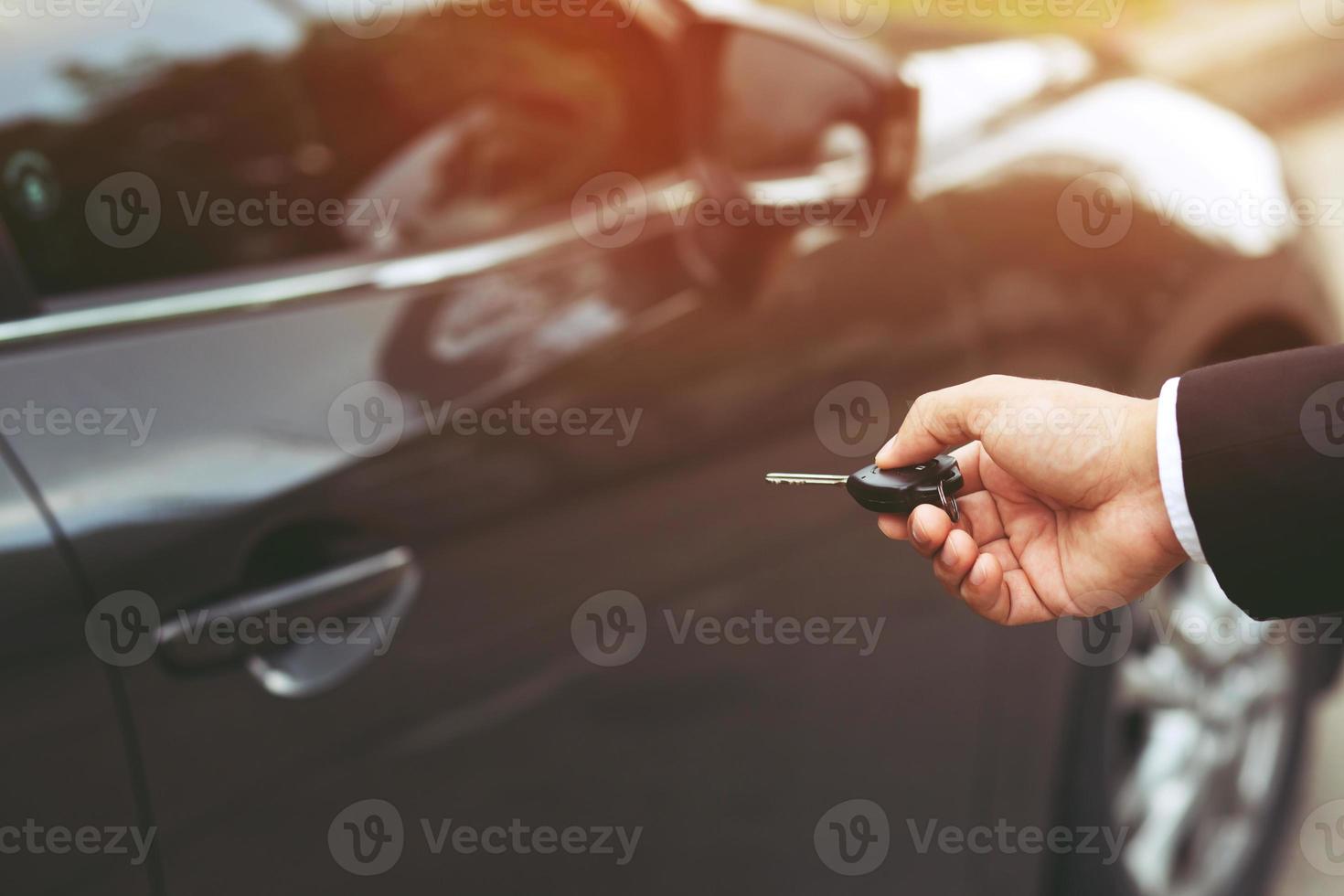 Autoschlüssel in der Hand eines Geschäftsmannes. Hand drückt auf die ferngesteuerten Autoalarmanlagen. verriegeln oder entriegeln Sie die Tür. Platz zum Schreiben von Text lassen. foto