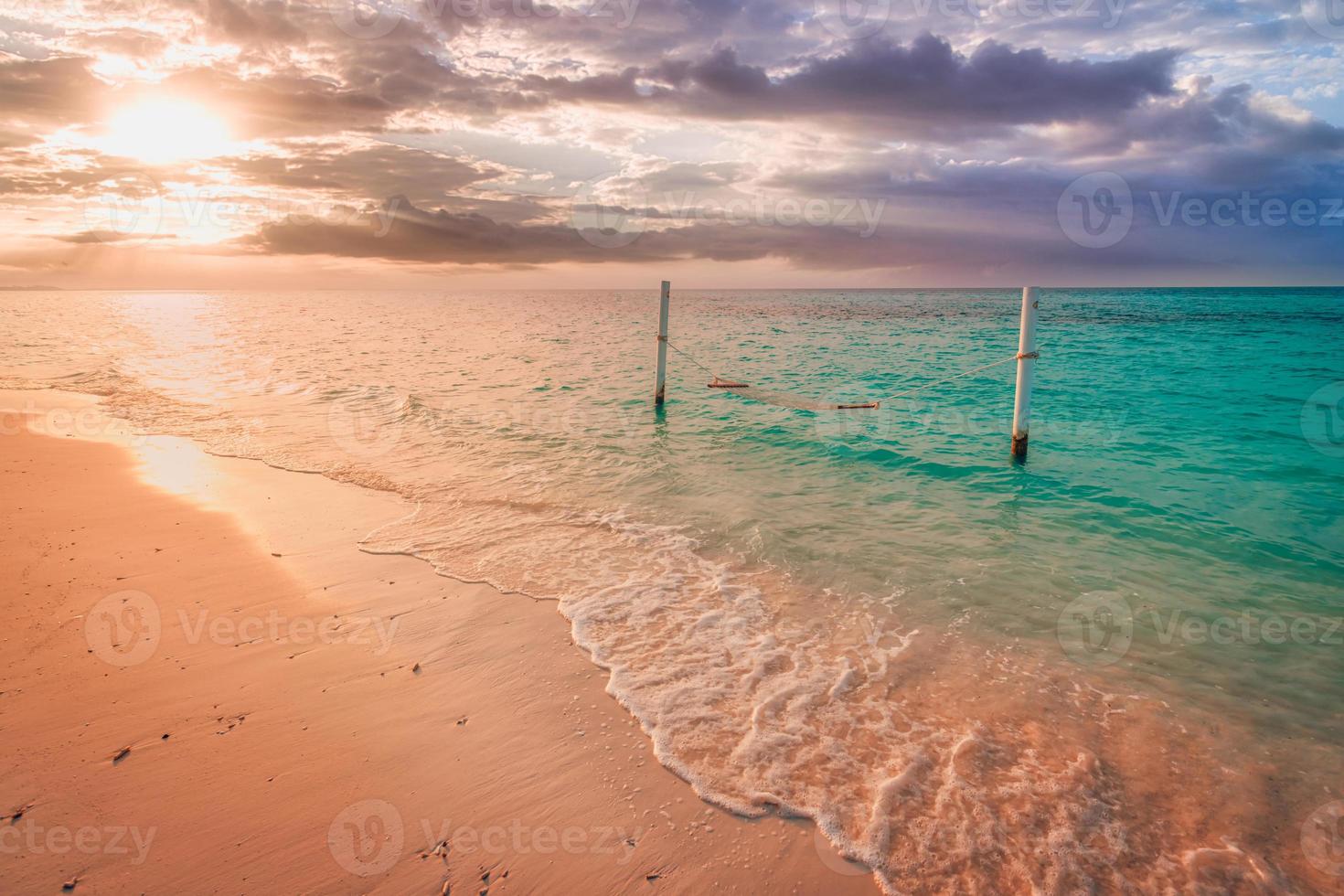 ruhige sommerferien oder urlaubslandschaft. Blick auf den tropischen Sonnenuntergang, Sandhimmel mit Meerwasserwellen, Hängematte über dem Wasser. ruhige exotische natur szenisch, inspirieren romantische seelandschaft reflexion, sonnenaufgang. foto