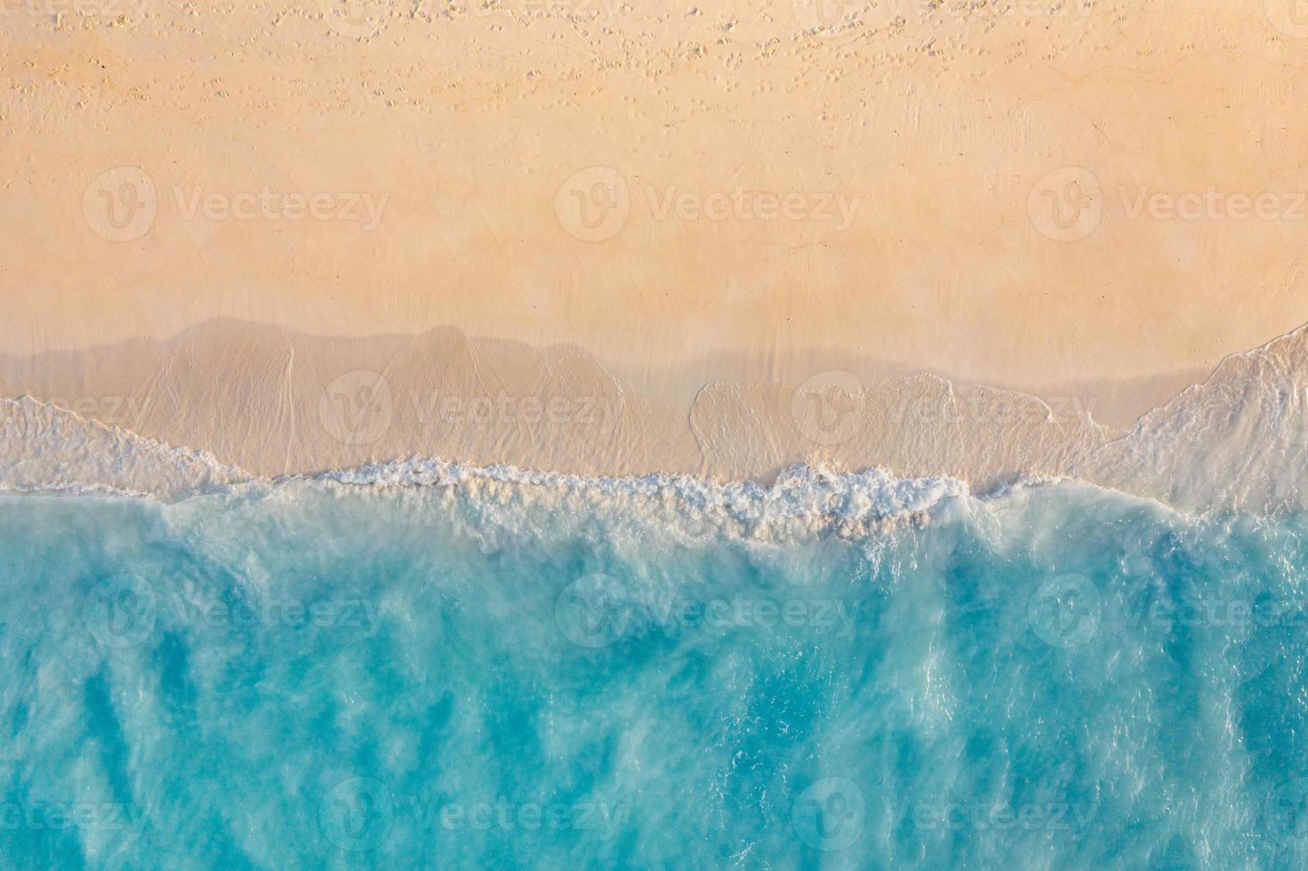 Sommermeerblick schöne Wellen, blaues Meerwasser an sonnigen Tagen. Draufsicht von der Drohne. Meeresluftbild, erstaunlicher tropischer Naturhintergrund. schöne helle meereswellen spritzen und sonnenunterganglicht am strandsand foto