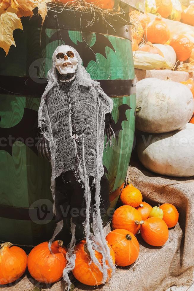 Halloween-Dekorationen. Skelett und frische Kürbisse. Bauernmarkt. Reifes Gemüse in Regalen zum Verkauf auf dem Land. foto