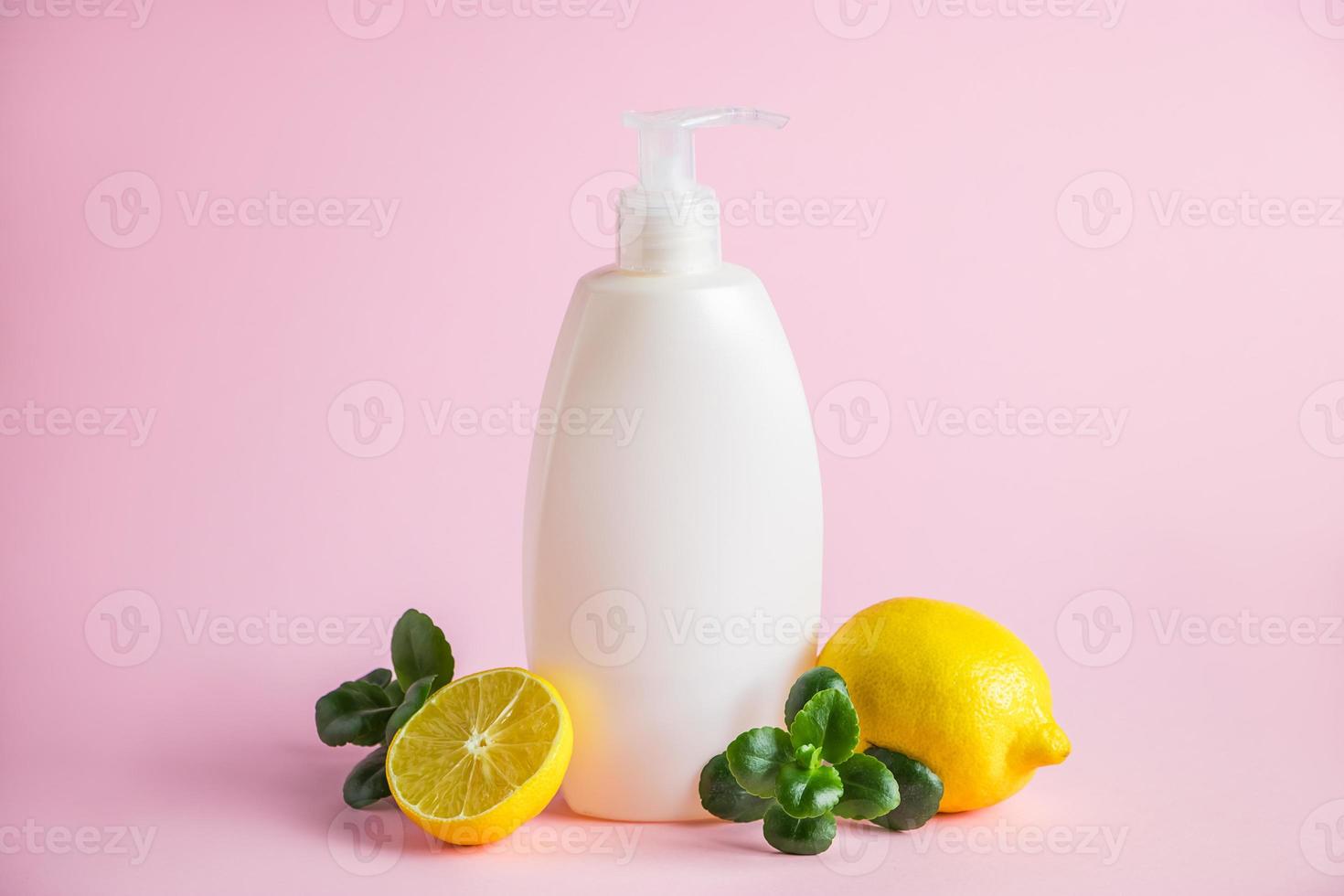 Bio-Kosmetik mit Zitronenöl. Flasche Feuchtigkeitscreme mit Zitrusfrüchten auf rosa Hintergrund. foto