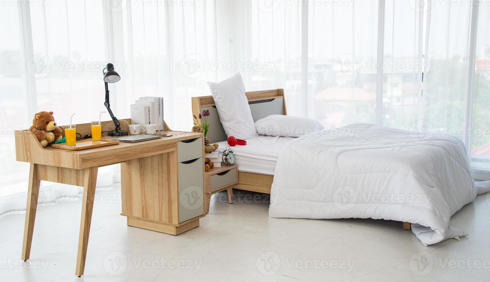 Das moderne oder minimalistische Innendesign des Schlafzimmers ist mit einem bequemen Doppelbett, weißer Bettwäsche wie Decken, Kissen und Holzmöbeln ausgestattet foto