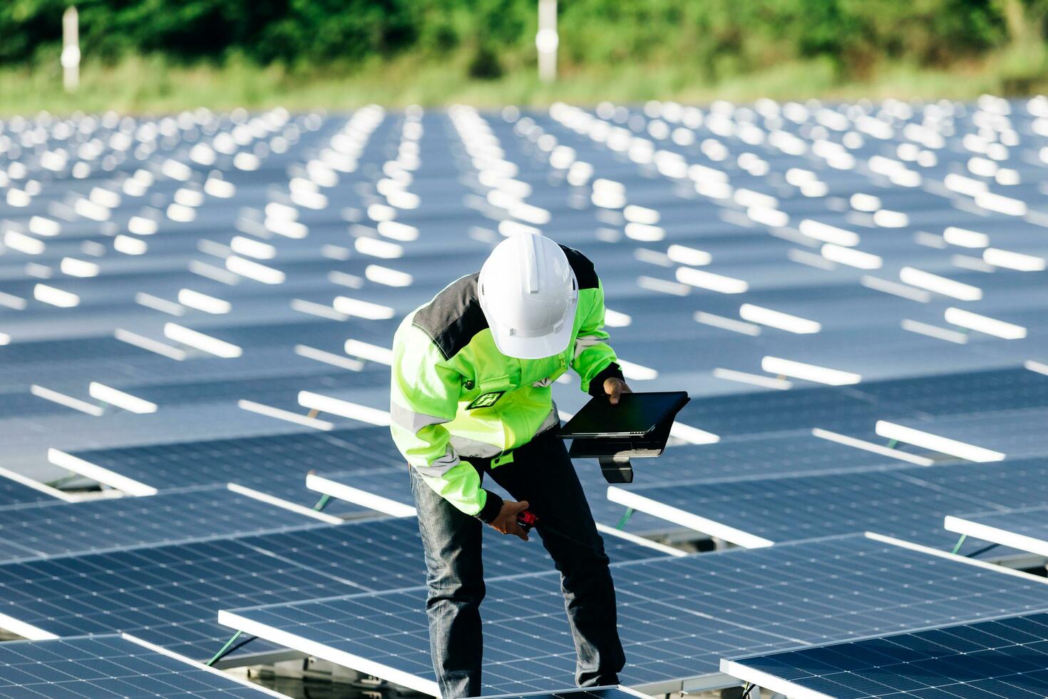 Das Porträt eines jungen Ingenieurs überprüft Photovoltaik-Solarmodule. Konzept. Erneuerbare Energietechnologie Stromdienst, Ökostrom. foto