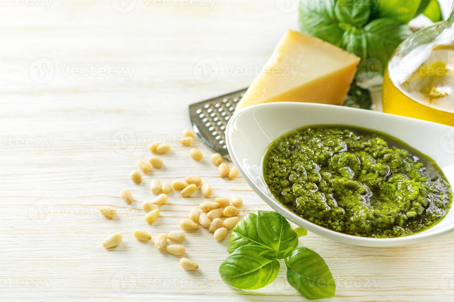 Hausgemachte Pesto-Sause mit Lebensmittelzutaten auf weißem Holzhintergrund foto