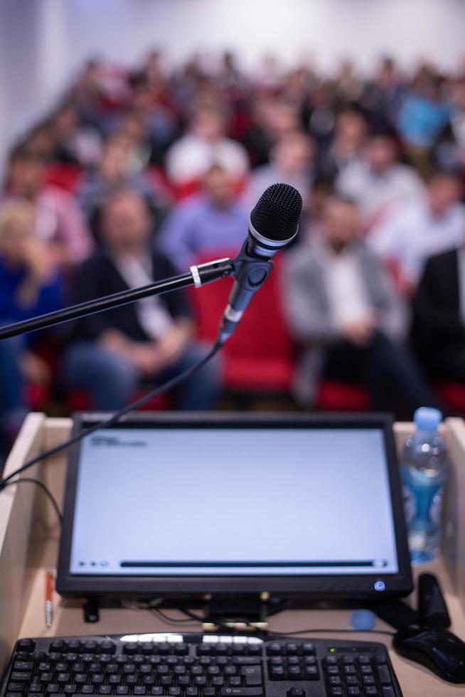 Laptop-Computer und Mikrofon auf dem Podium foto