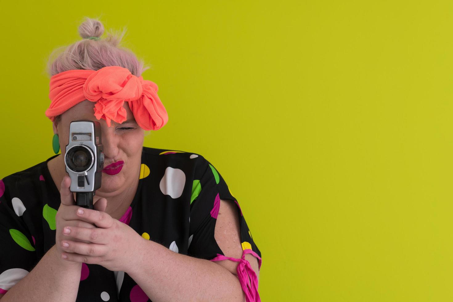 plus size lächelnde frau mit lustigem emotionalem gesichtsausdruck mit vintage-kamera im kleid lokalisiert auf grünem hintergrund, reisender im urlaub, sommermodestil, aufgeregter tourist. foto